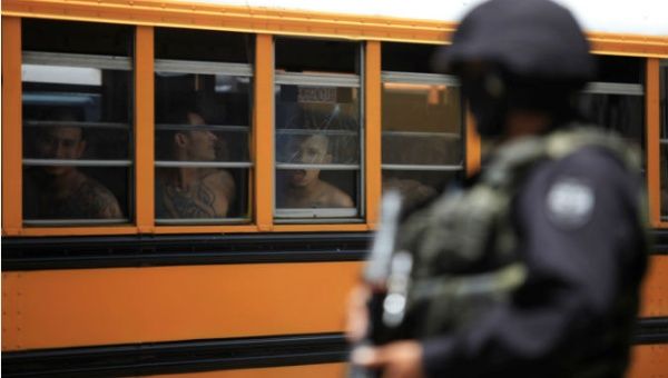 A Salvadoran policeman guards buses as 1,282 members of the Barrio 18 gang are transferred from a jail in Cojutepeque.