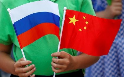 A child holds the national flags of Russia and China prior to a welcoming ceremony.