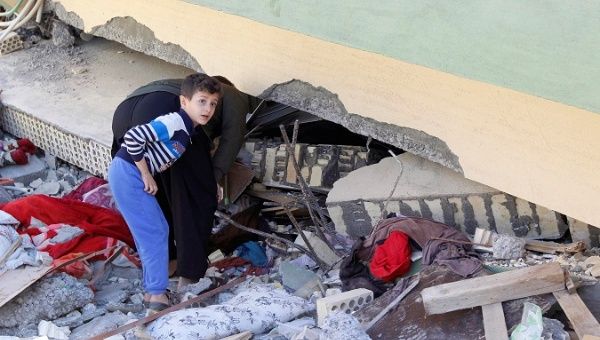 A man and child look at a damaged building following the 7.3 magnitude earthquake in the town of Darbandikhan, Iraq. 
