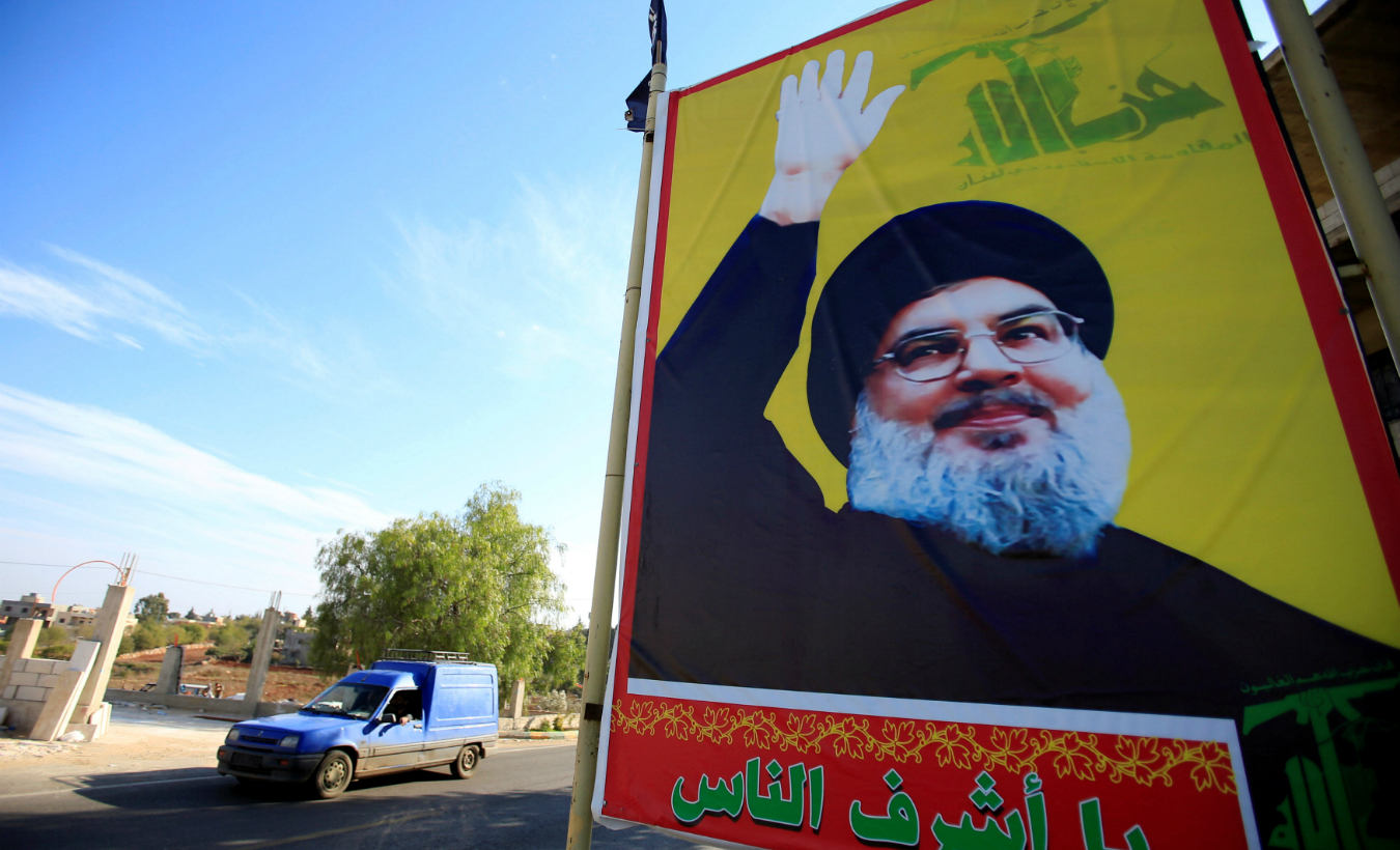 A car drives past a poster depicting Lebanon's Hezbollah leader Sayyed Hassan Nasrallah in Houla village, southern Lebanon, November 7, 2017.