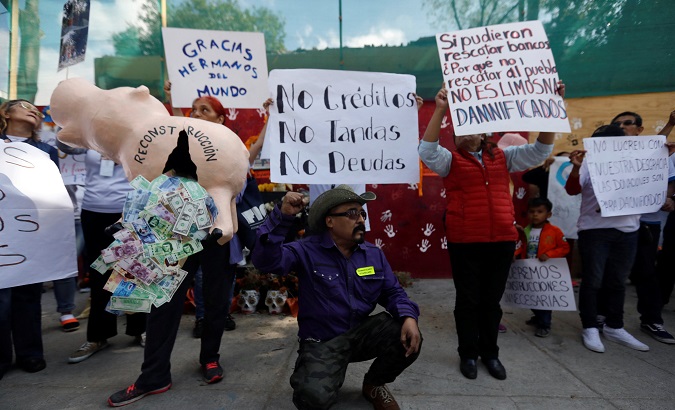 Victims hold signs as they protest against government's lack of response two months after deadly earthquake on September 19, in Mexico City, Mexico, November 19, 2017