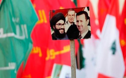  Supporters wave pictures of Hezbollah leader Nasrallah, Syria's late President Hafez al-Assad, and current Syrian President Bashar al-Assad. 