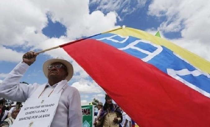 A man waves a flag during a march to support the peace process in Colombia.