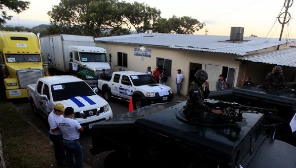 Military personnel wait to escort trucks with voting materials for distribution before the upcoming presidential election, in Tegucigalpa.