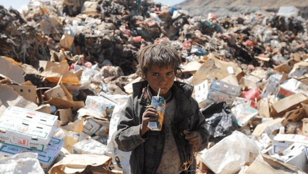A boy drinks expired juice on a pile of rubbish at a landfill site on the outskirts of Sanaa, Yemen, November 2016.