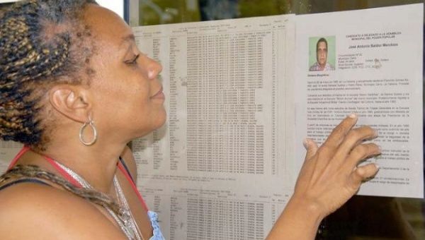 A woman reads the names of the candidates for a municipality in Havana.