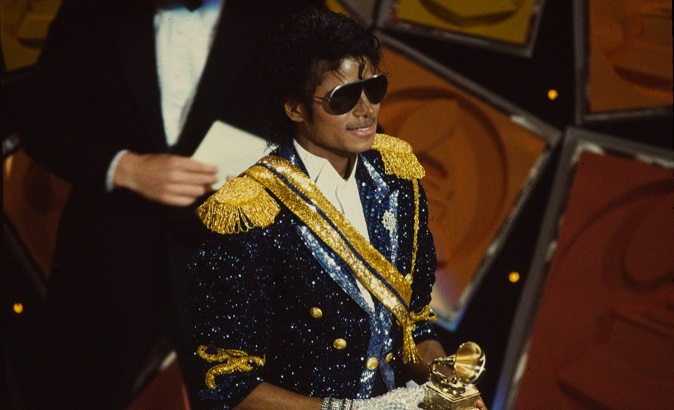 Michael Jackson pictured at the 26th annual Grammy Awards holding an award.