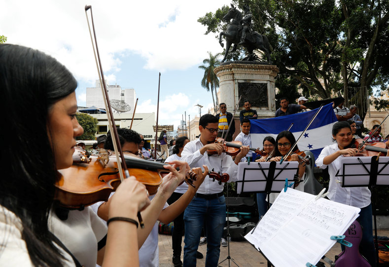 Musicians perform in the streets amid protests, calling for peace in Honduras.