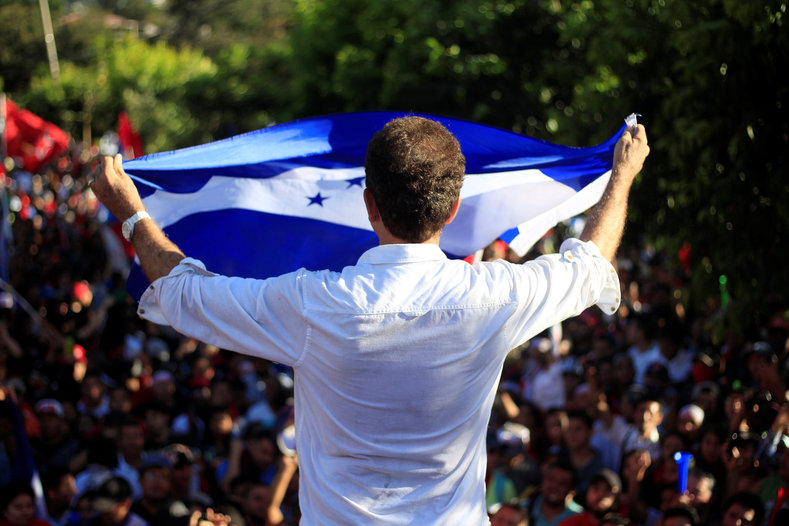 Opposition candidate Salvador Nasralla, who issued calls for resistance, holds a Honduran flag before supporters.