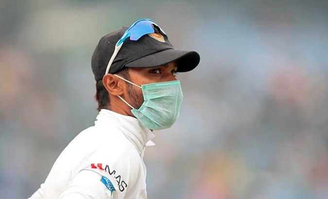 A Sri Lankan player wears a face mask to protect himself from India's choking smog during a cricket match.