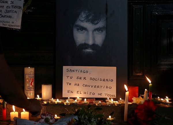 A man lights candles next to a portrait of Santiago Maldonado, who went missing after security forces clashed with indigenous activists in Patagonia on August 1.