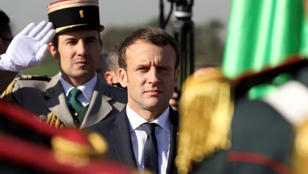 French President Emmanuel Macron reviews troops at Algiers Airport following his arrival in Algeria, December 6. 