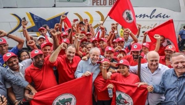 Lula (center) shows support for the Landless Workers' Movement, MST, on his caravan bus tour.