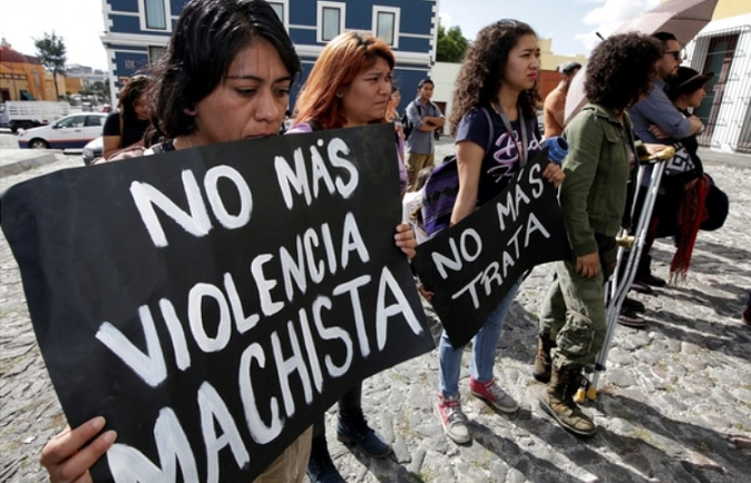 Women attending a protest against femicide in Mexico hold aloft a banner declaring: 