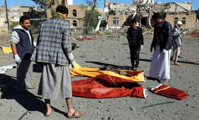 Yemenis collect the corpses of people killed in Saudi airstrike in Sana'a
