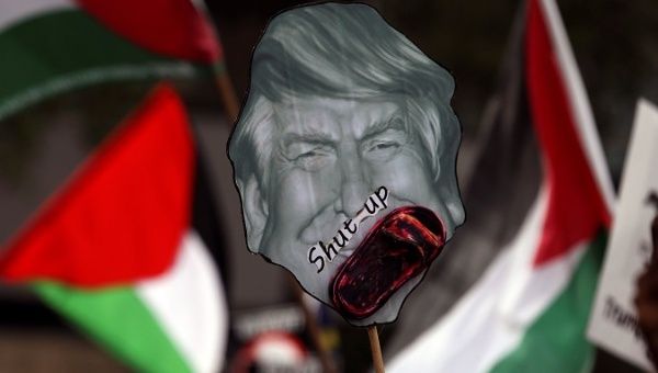 Pro-Palestine protesters hold a placard of U.S. President Donald Trump as they march towards the U.S. Embassy in Kuala Lumpur, Malaysia Dec. 15, 2017.