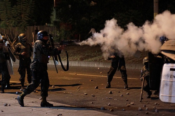 Police fire tear gas towards opposition supporters during a protest after Honduras' President Juan Orlando Hernandez declared himself re-elected.