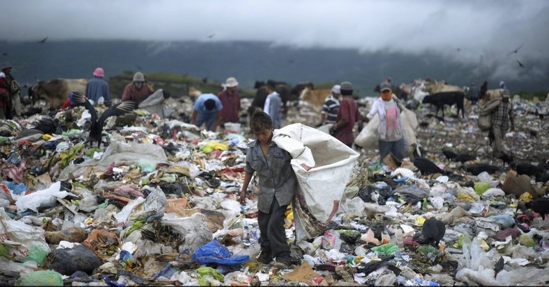 A young boy collects waste at a landfill on the outskirts of Tegucigalpa, Honduras. According to the World Bank, 64.5 percent of the population in Honduras lives in poverty while 42.6 percent live in extreme poverty (less than US$2.50 per day). Photo:Reuters