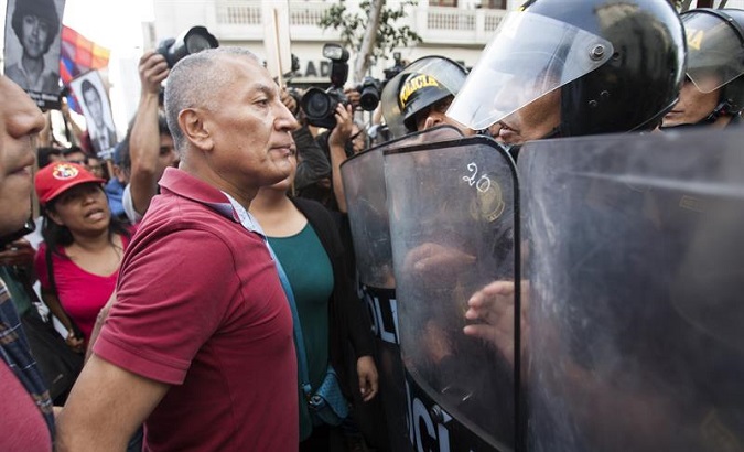 A Peruvian protester faces riot police in demonstrations against the pardon of former dictator Alberto Fujimori.