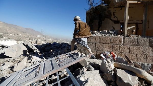 A man walks past a destroyed house at the site of airstrikes in Sanaa, Yemen Dec. 26, 2017.