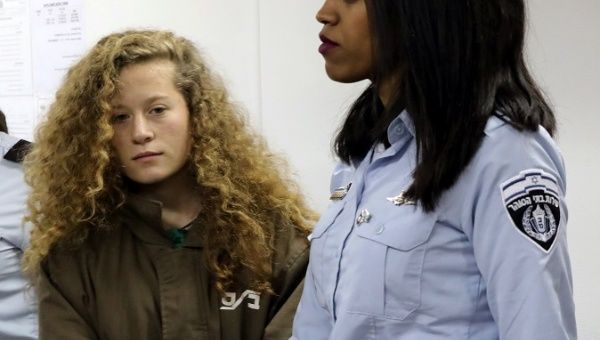 Palestinian teen Ahed Tamimi enters an Israeli courtroom escorted at Ofer Prison near the West Bank city of Ramallah, Dec. 28, 2017. 