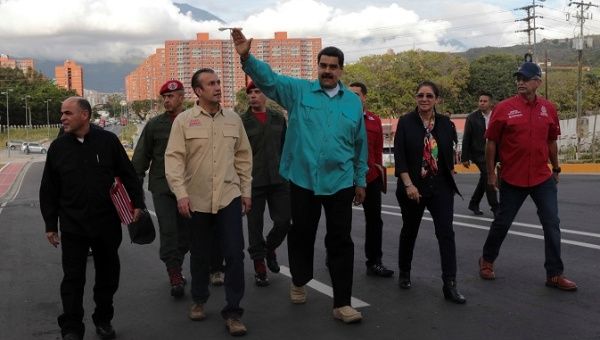 Venezuelan President Nicolas Maduro (C) waves as he arrives for an event to hand over residences built under the government's housing program.