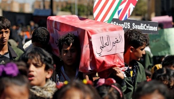 Children carry a mock coffin during a protest against the Saudi-led coalition outside the UN offices in Sanaa, Yemen Nov. 20, 2017.