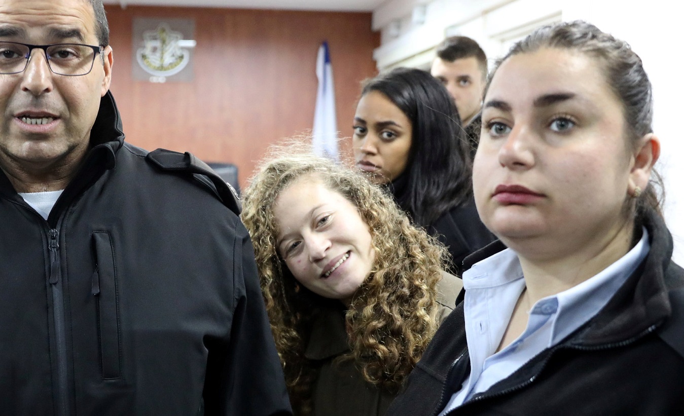 Palestinian teen Ahed Tamimi enters a military courtroom escorted by Israeli Prison Service personnel at Ofer Prison, near the West Bank city of Ramallah, Jan. 1, 2018.