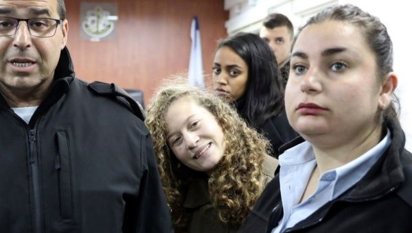 Palestinian teen Ahed Tamimi enters a military courtroom escorted by Israeli Prison Service personnel at Ofer Prison, near the West Bank city of Ramallah, Jan. 1, 2018. 