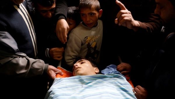 People gather around the body of Mosab Tamimi, who was killed during clashes with Israeli troops, at a hospital in the West Bank city of Ramallah Jan. 3, 2018.