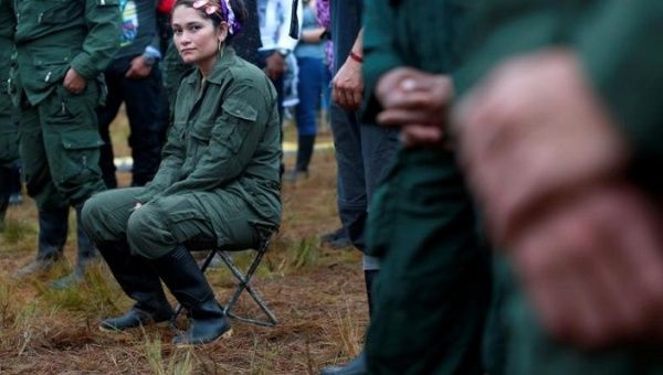 A fighter from FARC seats during the opening of ceremony congress at the camp where they prepare for ratifying a peace deal with the government, near El Diamante in Yari Plains, Colombia. Sept. 16, 2016.