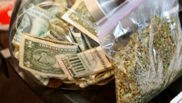 A bag of marijuana being prepared for sale sits next to a money jar at BotanaCare in Northglenn, Colorado, U.S., Dec. 31, 2013.