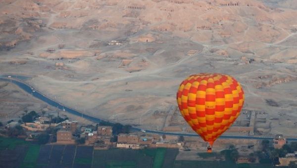 A hot-air balloon flies over the village of al-Qurna, situated over more than 500 pharaonic tombs at the feet of the Theban Mountains, in the city of Luxor, Egypt.
