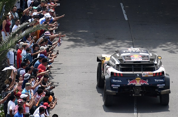 Crowds wave at Peugeot Total driver Sebastien Loeb and copilot Daniel Elena.
