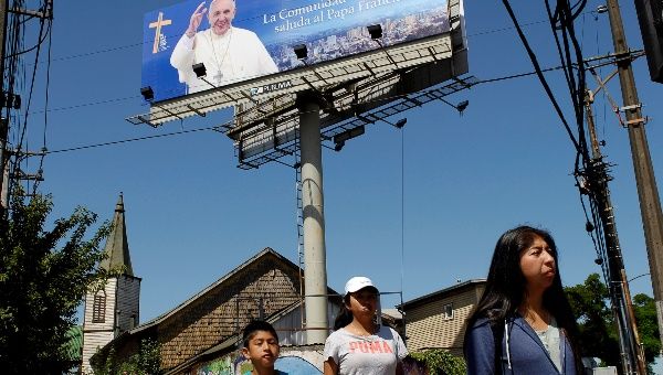 Locals walk past a banner of Pope Francis ahead of the papal visit, in Temuco, Chile Jan. 10, 2018.