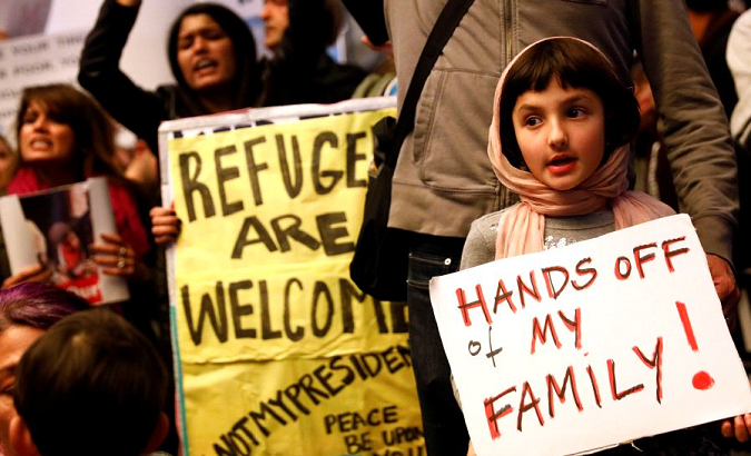 A girl holds a sign in support of Muslim family as people protest against U.S. President Donald Trump's travel ban.