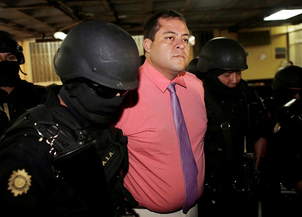 Julio Juarez Ramirez, accused of plotting the murders of two journalists in 2015, is escorted by police officers to court in Guatemala City.