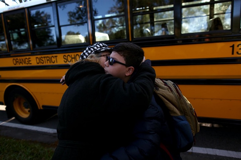 Puerto Rican Felix Rodriguez, 11, hugs his mother Nydia Irizarry, 45, before a school bus picks him up outside a hotel where he lives with his family.