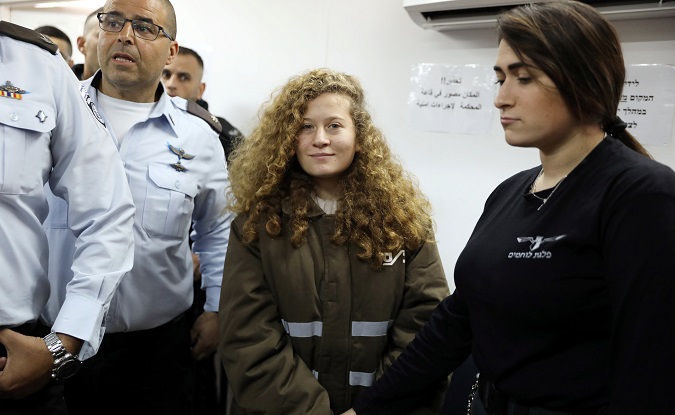 Palestinian teen Ahed Tamimi enters a military courtroom escorted by Israeli security personnel at Ofer Prison, near the West Bank city of Ramallah, Jan. 15.