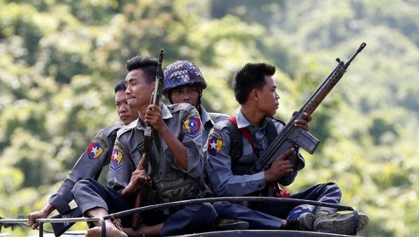 Myanmar police guard a U.N. convoy.