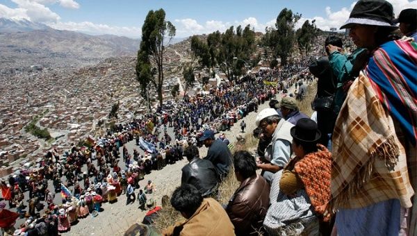 People from El Alto in Bolivia watch cam´paigners marching in support of a constitutional referendum vote in 2008.