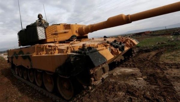 A Turkish soldier sits on a tank as Turkish troops prepare near the Syrian-Turkish border at Reyhanli district in Hatay, Turkey.