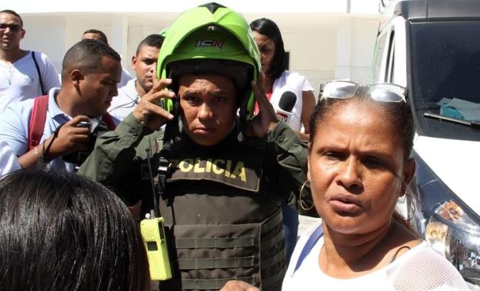 A Colombian policeman and family members transport wounded officers to a hospital after a bomb explosion at a police station in Barranquilla, Colombia.