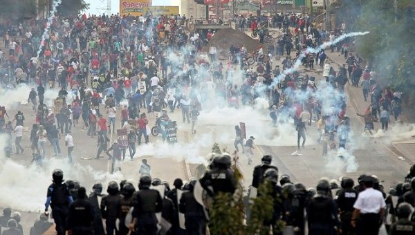 Demonstrators clash with riot police and soldiers during a protest as Honduran President Juan Orlando Hernandez is sworn in for a new term in Tegucigalpa