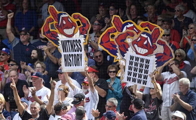 Fans hold signs in the first inning of a game between the Cleveland Indians and the Detroit Tigers at Progressive Field.