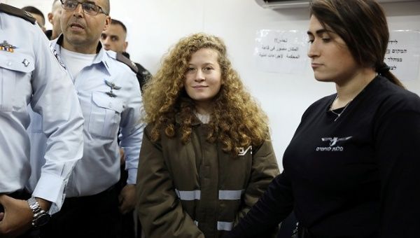 Palestinian teen Ahed Tamimi enters a military courtroom escorted by Israeli security personnel at Ofer Prison, near the West Bank city of Ramallah, Jan. 15.