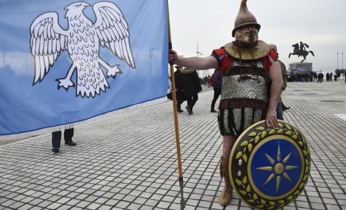 A protester wears an ancient Greek costume during a rally against the use of the term 