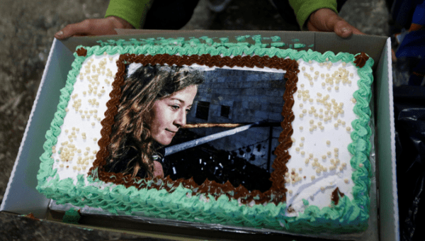 A man displays a cake with the picture of Palestinian teen Ahed Tamimi, who is detained by Israel, during a symbolic birthday party for Tamimi in the West Bank city of Hebron January 30, 2018.