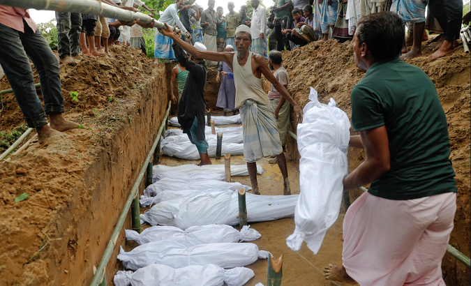 Rohingya refugees, who died after their boat capsized as they were fleeing from Myanmar, are buried in a mass grave just behind Inani beach near Cox's Bazar, Bangladesh September 29, 2017.