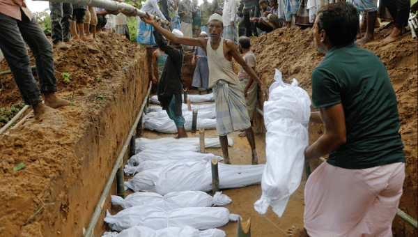 Rohingya refugees, who died after their boat capsized as they were fleeing from Myanmar, are buried in a mass grave just behind Inani beach near Cox's Bazar, Bangladesh September 29, 2017.